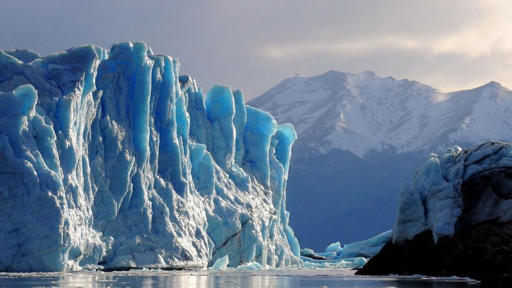 Majestic Icebergs Beneath a Cloudy Sky wallpaper
