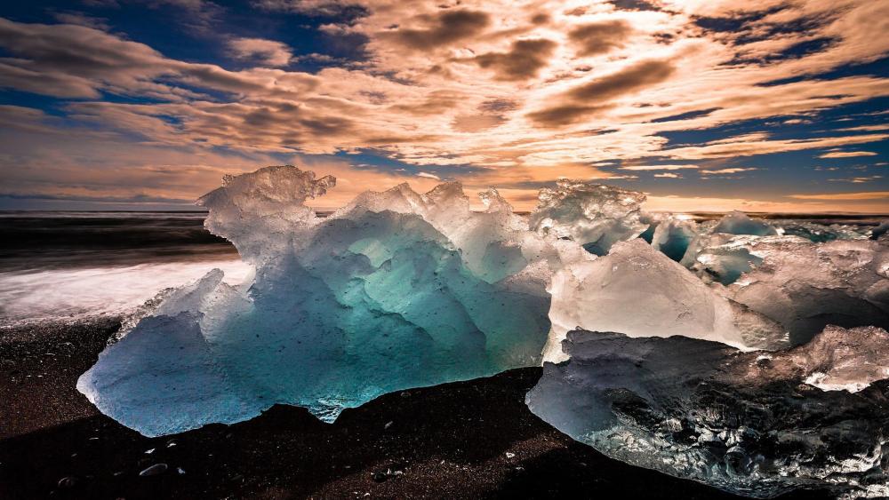 Crystal Blue Icebergs Against a Dramatic Sky wallpaper