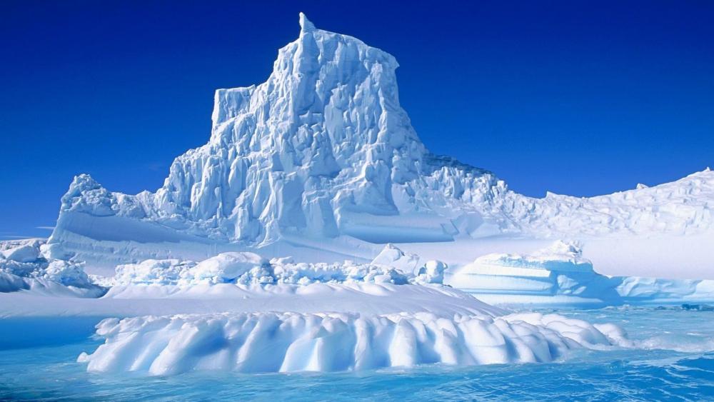 Majestic Iceberg Beneath a Clear Sky wallpaper