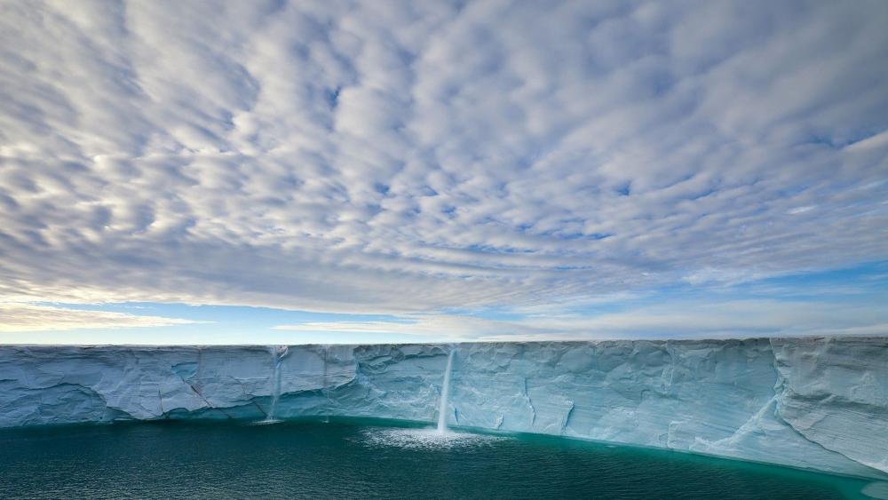Majestic Ice Cliff with Dramatic Cloudscapes wallpaper