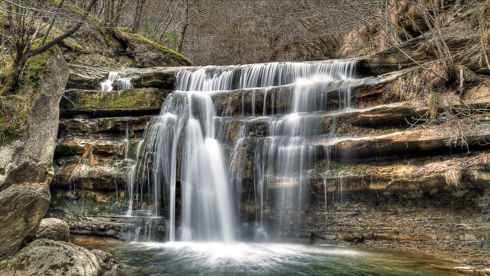 Serene Waterfall in a Tranquil Forest Scene wallpaper