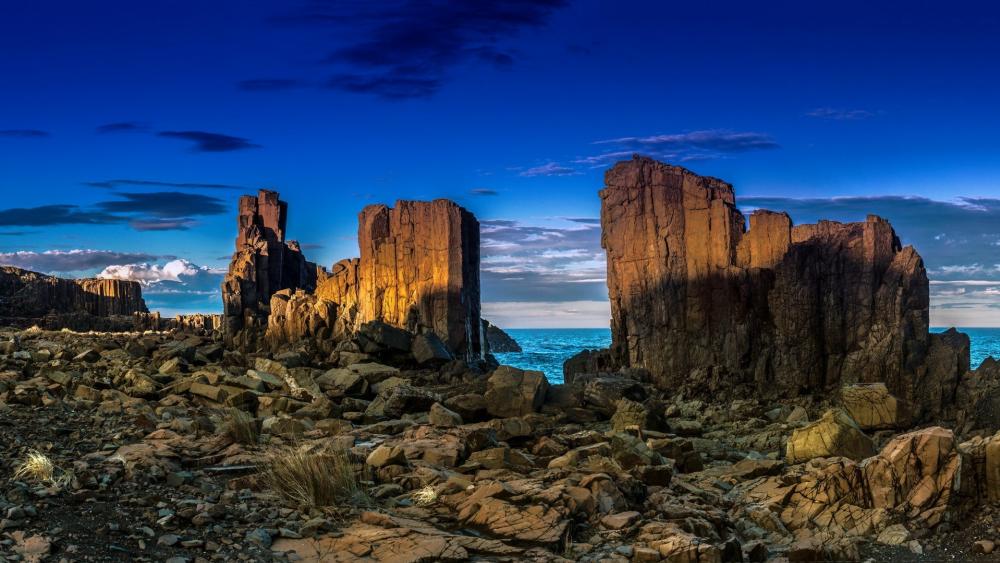 Majestic Coastal Rock Formations Under Twilight Sky wallpaper