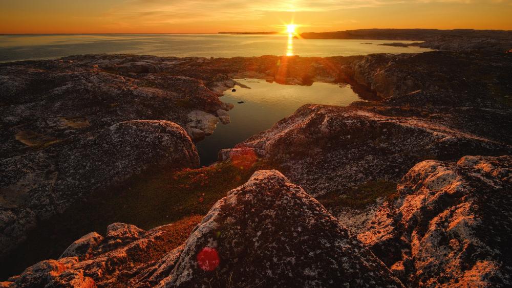 Eternal Sunset Over Rocky Coastline wallpaper