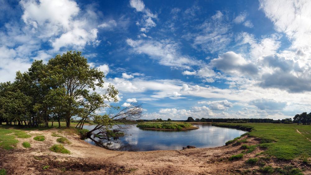 Tranquil Riverbank Under a Vast Sky wallpaper