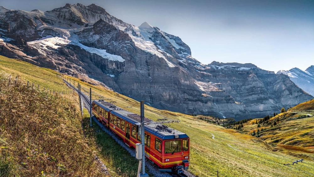 Scenic Train Journey Through Majestic Mountains wallpaper