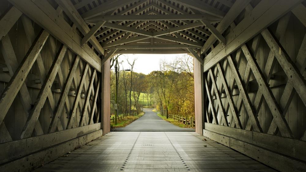 Tranquil Pathway through a Historic Covered Bridge wallpaper