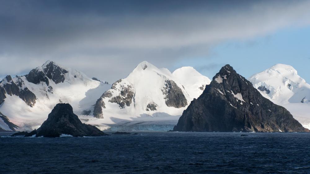 Majestic Snow-Capped Peaks Over Turquoise Waters wallpaper