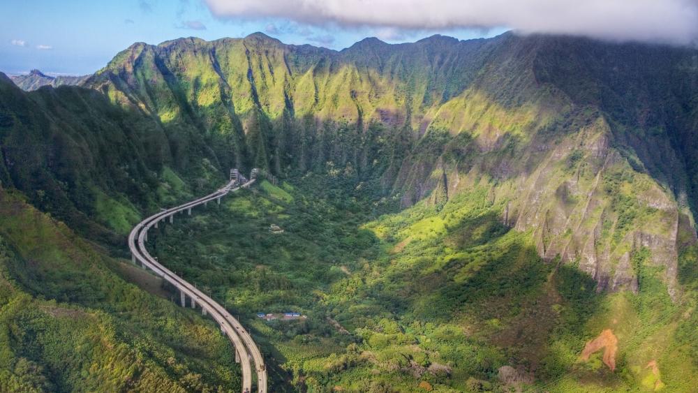 Majestic Mountain Roadway in Lush Green Landscape wallpaper
