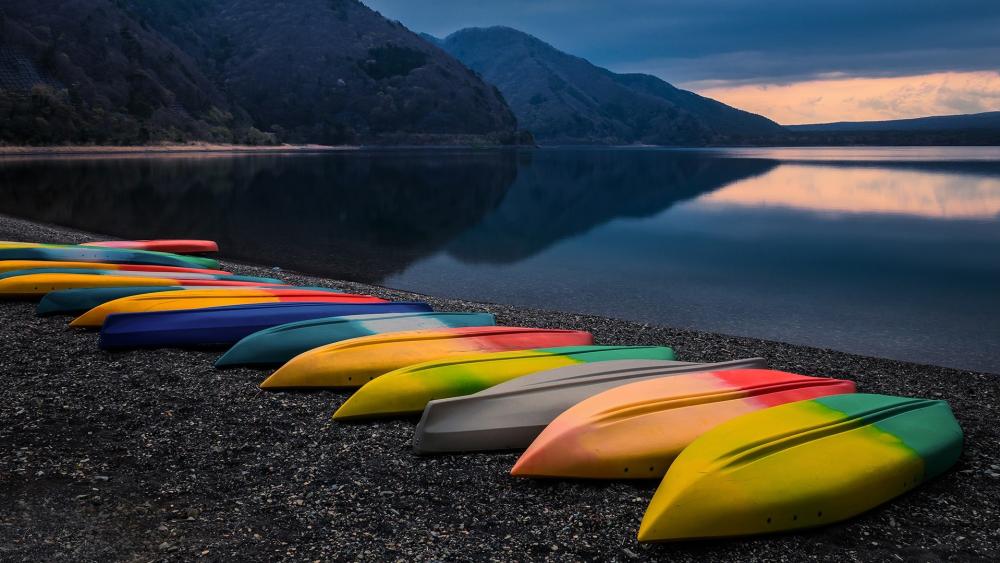 Vibrant Kayaks Resting by Serene Waters wallpaper