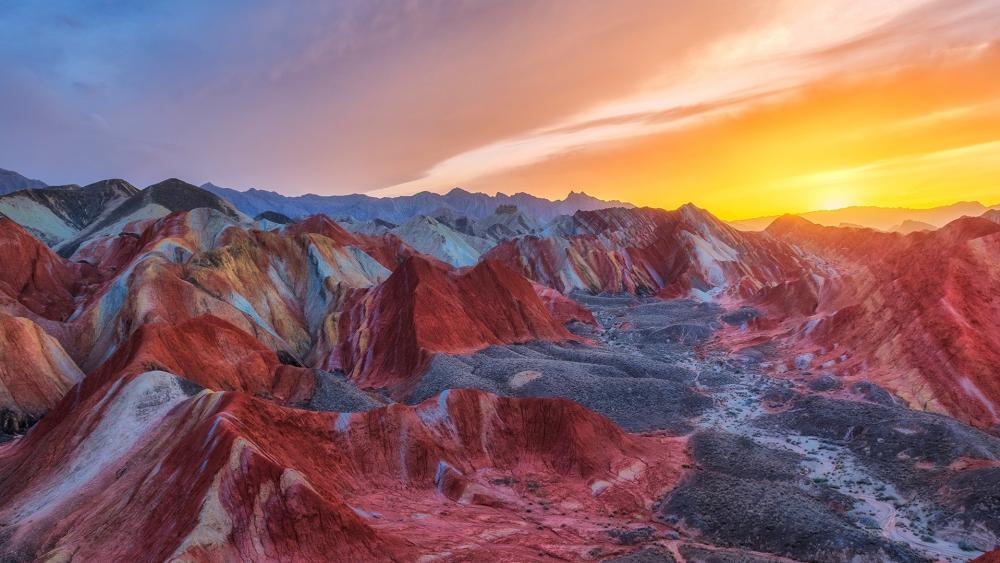 Vibrant Sunset Over Colorful Mountain Ranges wallpaper