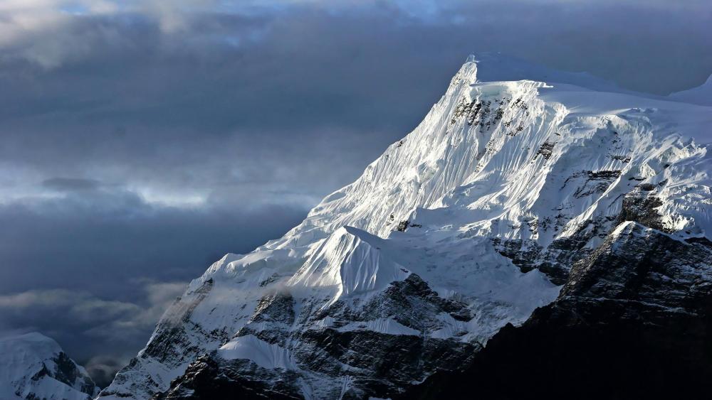 Majestic Snow-Capped Peaks Under Dramatic Skies wallpaper