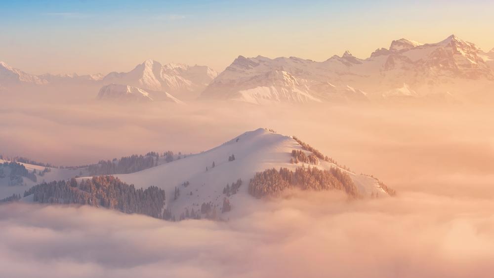Majestic Snowy Mountains Under Soft Sunrise Glow wallpaper
