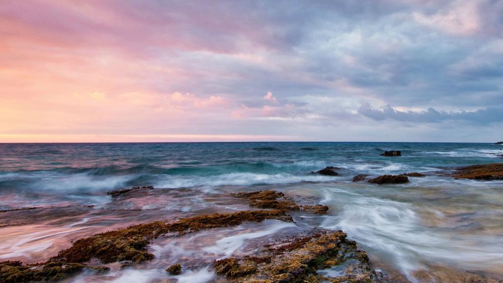 Serene Coastal Sunset Over Rocky Shoreline wallpaper