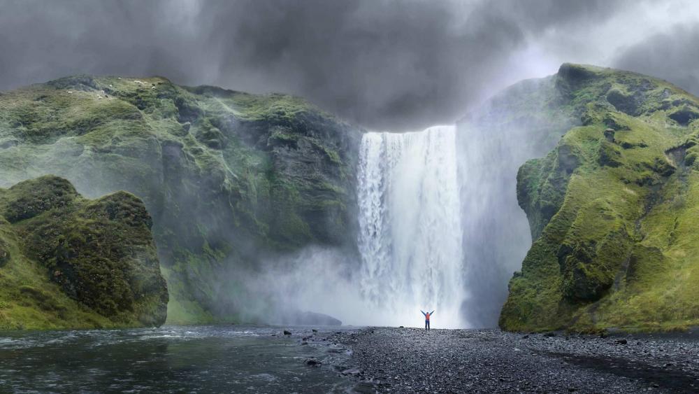 Majestic Waterfall in a Dramatic Landscape wallpaper