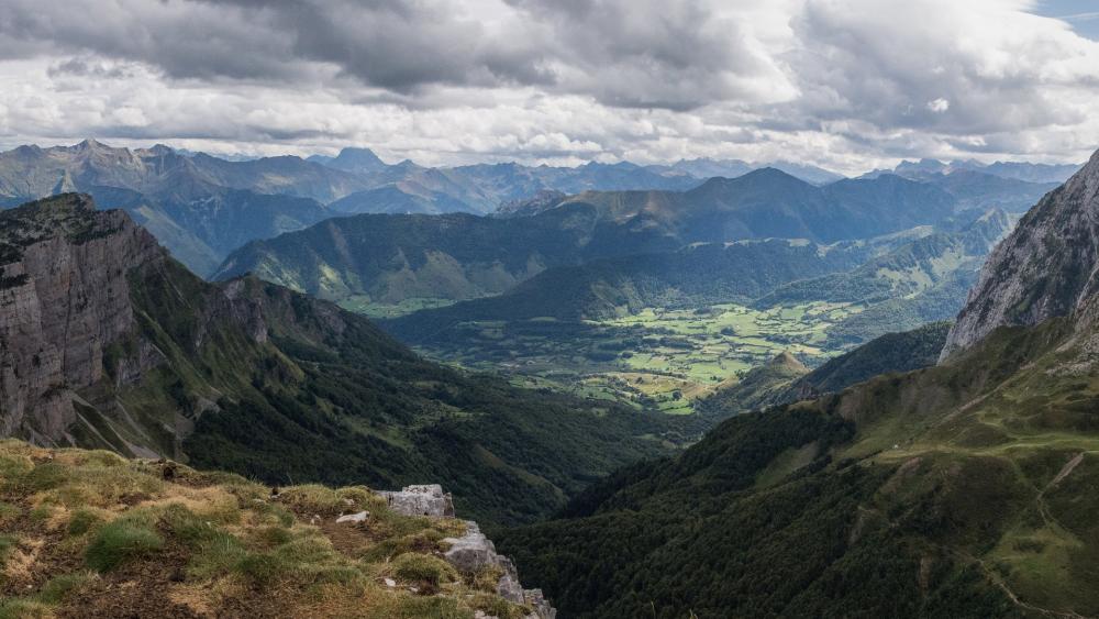 Majestic Mountain Valley Under Dramatic Clouds wallpaper