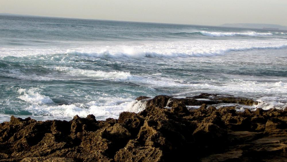 Serene Seashore Waves and Rocky Coastline wallpaper