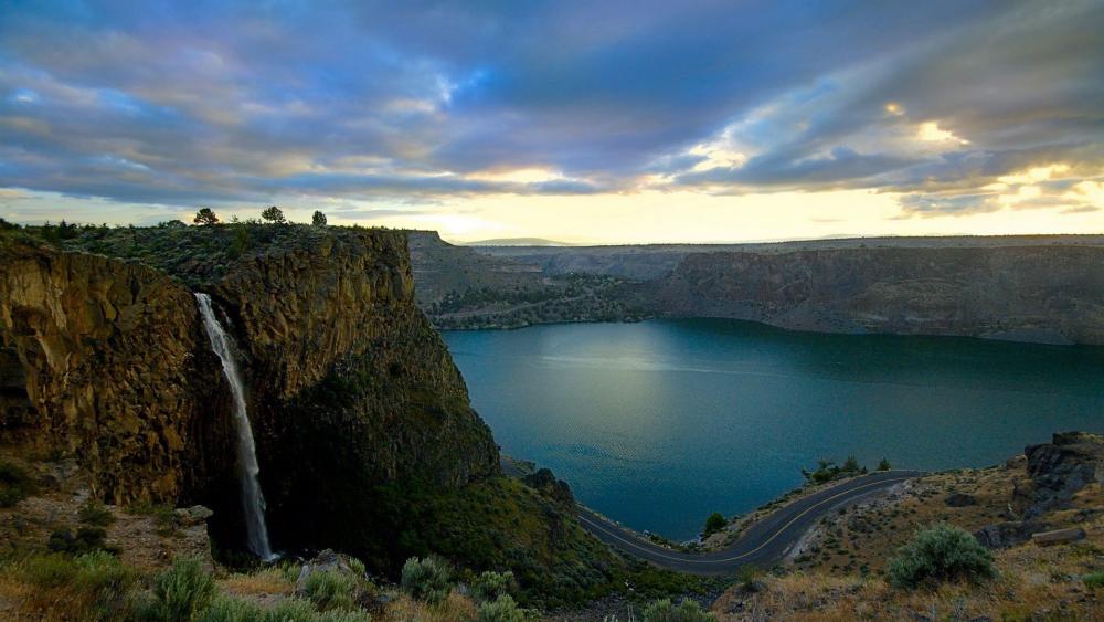 Majestic Waterfall Over Serene Lake Landscape wallpaper