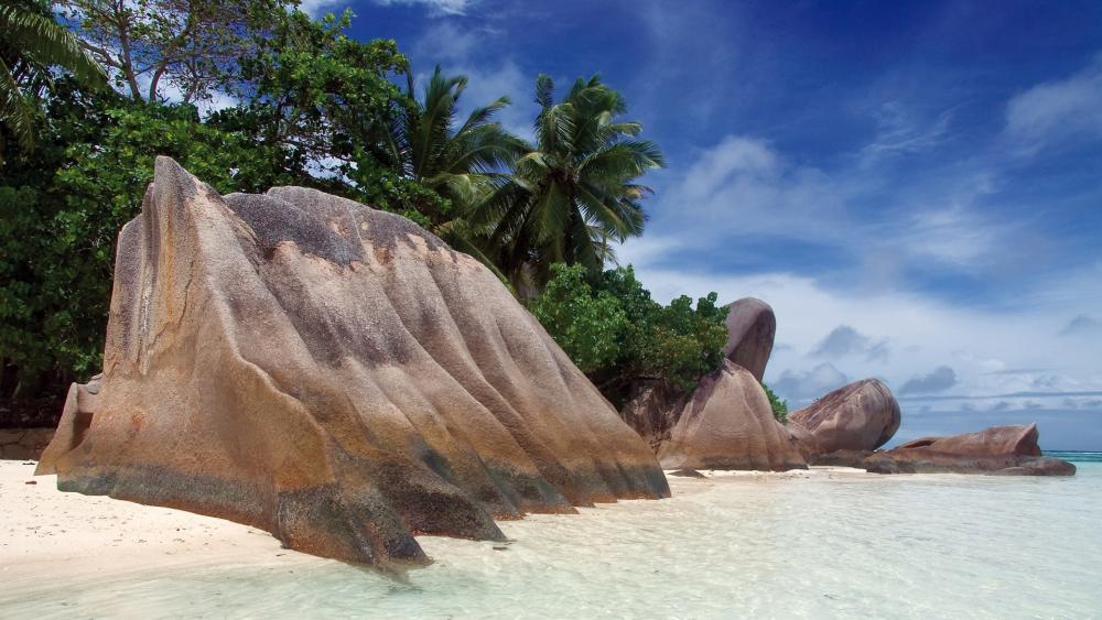 Serene Coastal Landscape with Majestic Rocks and Lush Foliage wallpaper