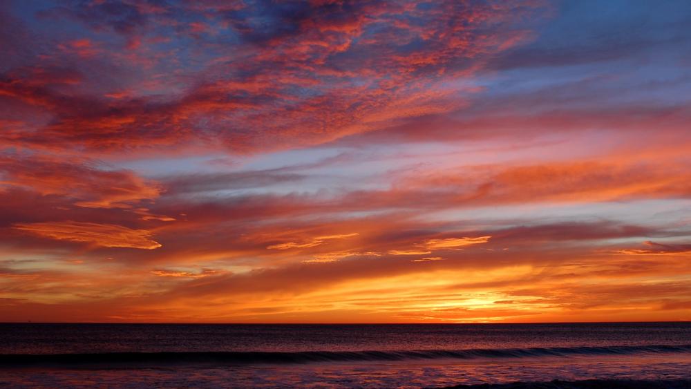 Vibrant Sunset Over Tranquil Ocean Waves wallpaper