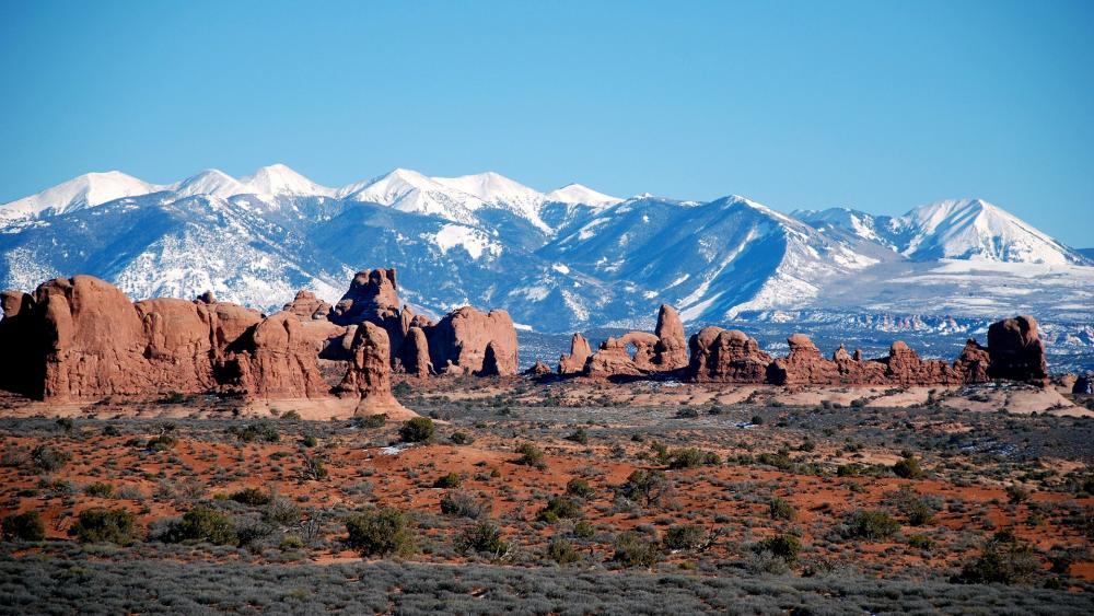 Majestic Desert Landscapes Under Snow-Capped Peaks wallpaper