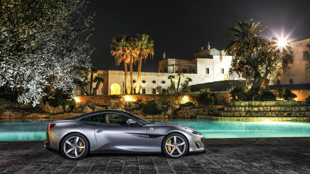 Sleek Ferrari Under Moonlit Sky in Luxurious Setting wallpaper