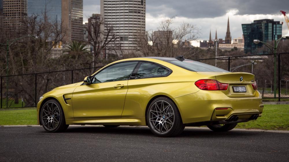Sleek Yellow BMW Coupe in Urban Landscape wallpaper