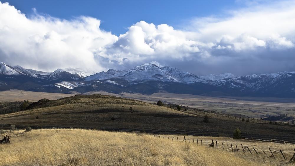 Majestic Snow-Capped Mountains Under Dramatic Clouds wallpaper