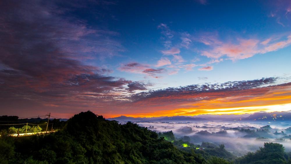 Sunrise Over Misty Mountains Amidst Colorful Skies wallpaper