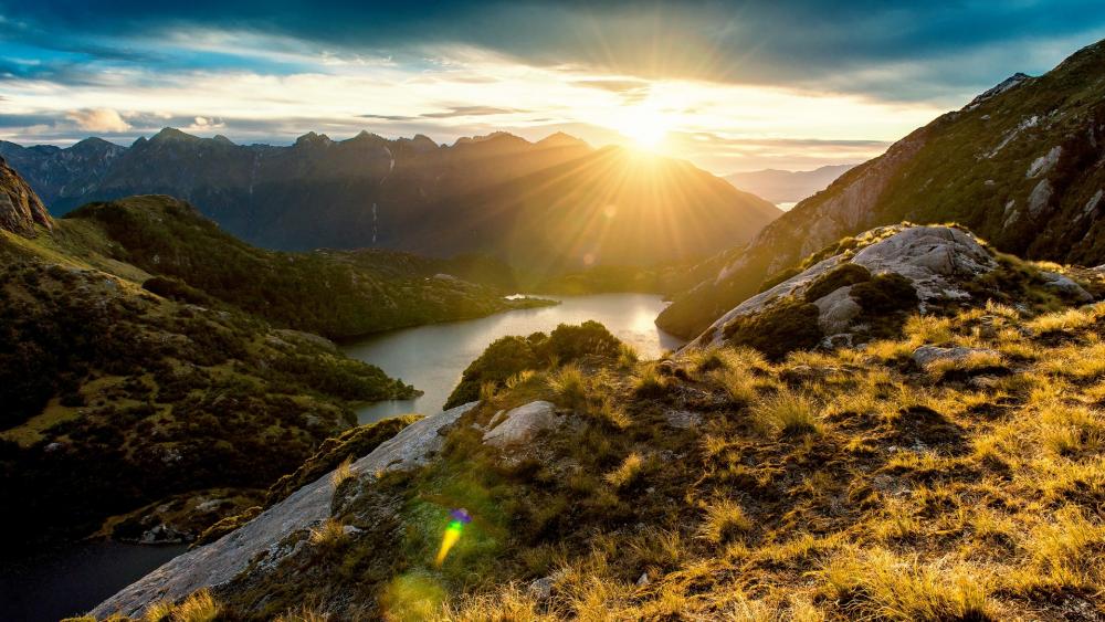 Golden Sunrise Over Tranquil Lake and Mountains wallpaper
