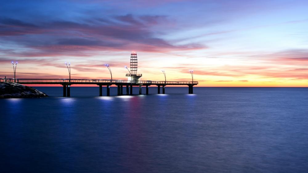 Serene Sunset Over Lighthouse Pier wallpaper