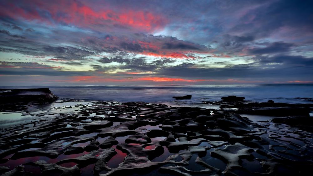 Stunning Sunset Over Rocky Shoreline wallpaper