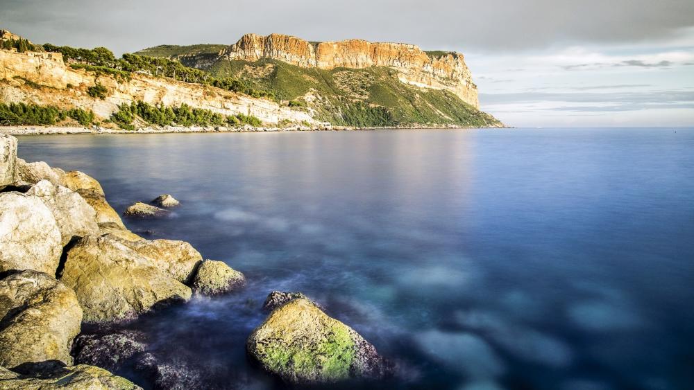 Serene Coastal Landscape with Cliffs and Calm Waters wallpaper