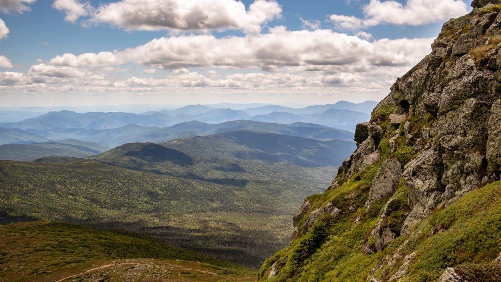 Majestic Mountain Range Under Blue Skies wallpaper