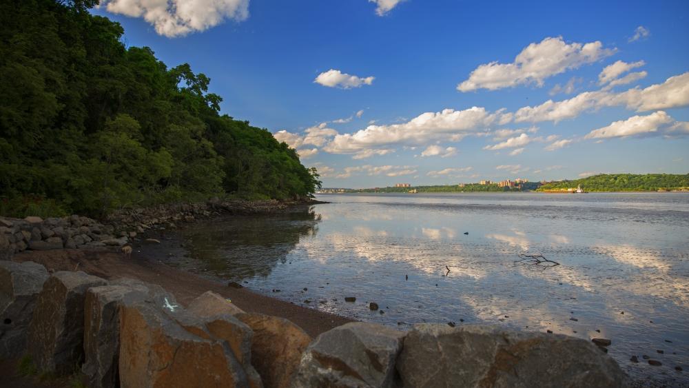 Scenic Riverbank Under Blue Sky wallpaper