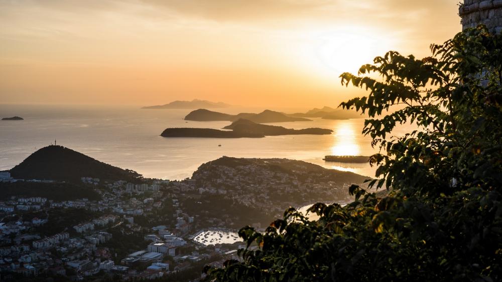 Serene Sunset Over Tranquil Islands in the Horizon wallpaper