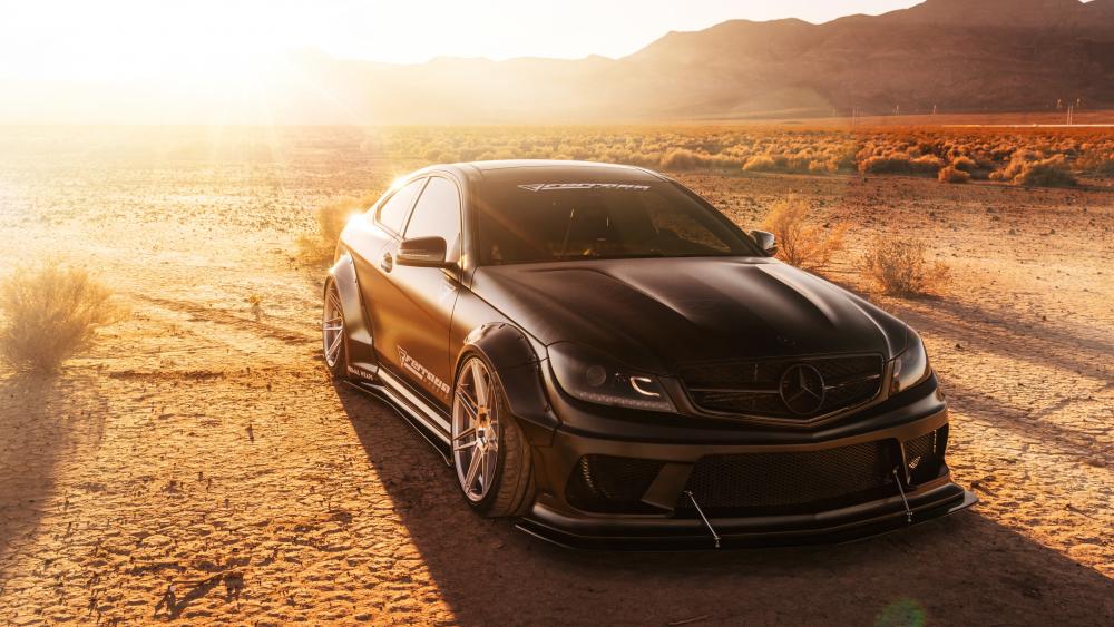 Sleek Black Luxury Car in Desert Sunset wallpaper