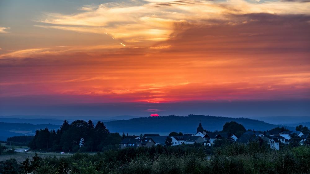 Vibrant Sunset Over Countryside Village wallpaper