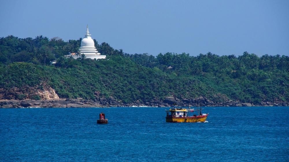 Serene Coastal Scene with Fishing Boat and Pagoda wallpaper
