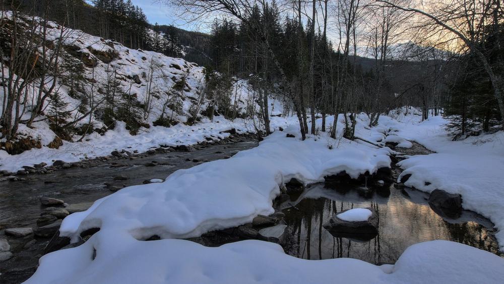 Serene Winter Stream in a Snowy Landscape wallpaper