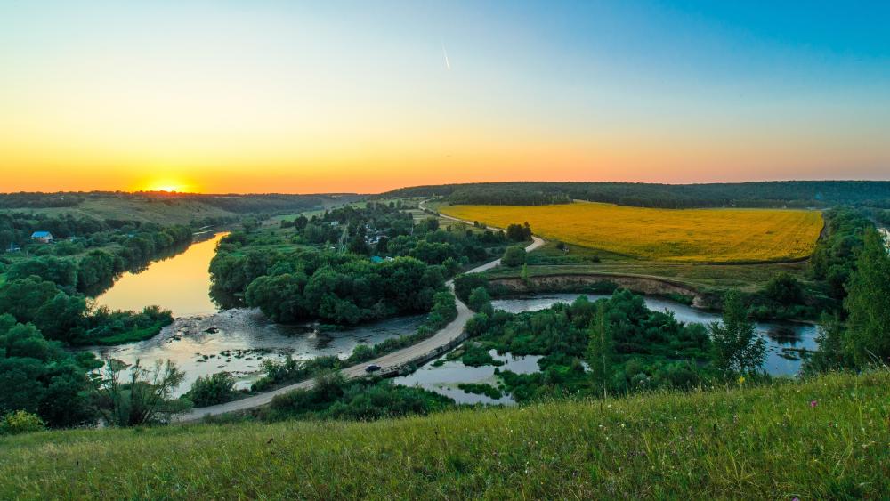 Serene Sunset Over Rolling Hills and Rivers wallpaper