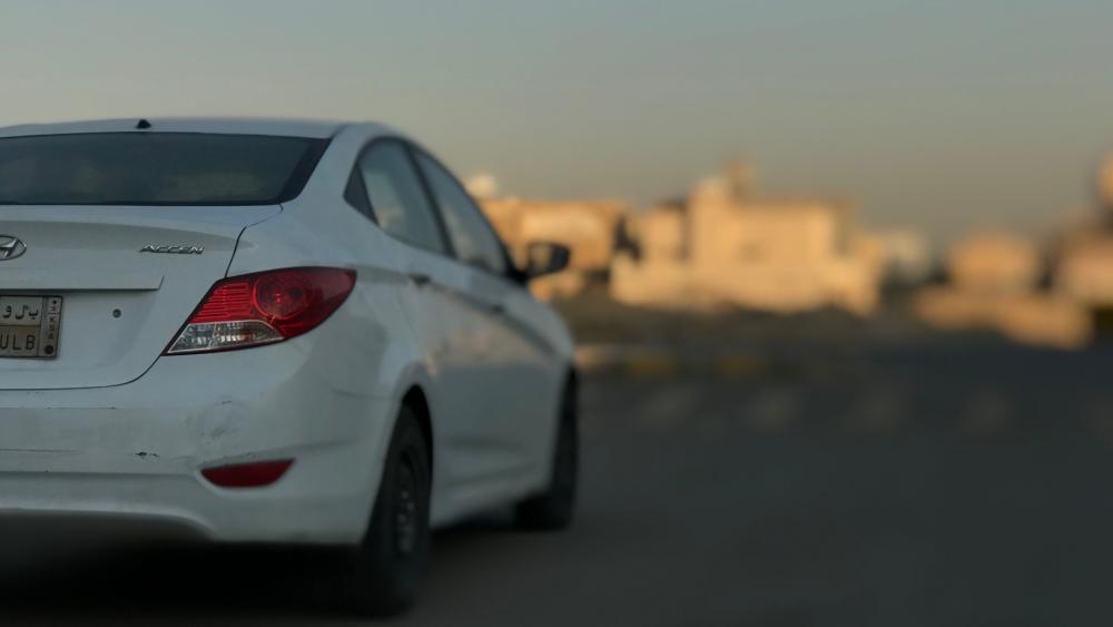 Sleek White Car on Urban Road wallpaper