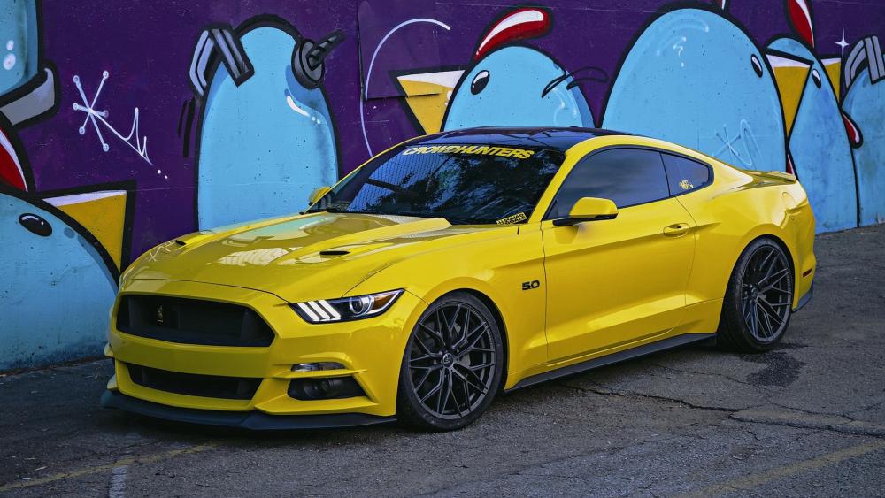 Bold Yellow Mustang Against Vibrant Street Art Background wallpaper
