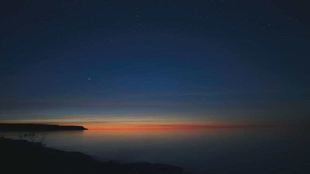 Starry Horizon Over Tranquil Shore wallpaper