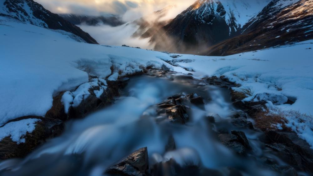 Majestic Mountain Stream in Snowy Landscape wallpaper