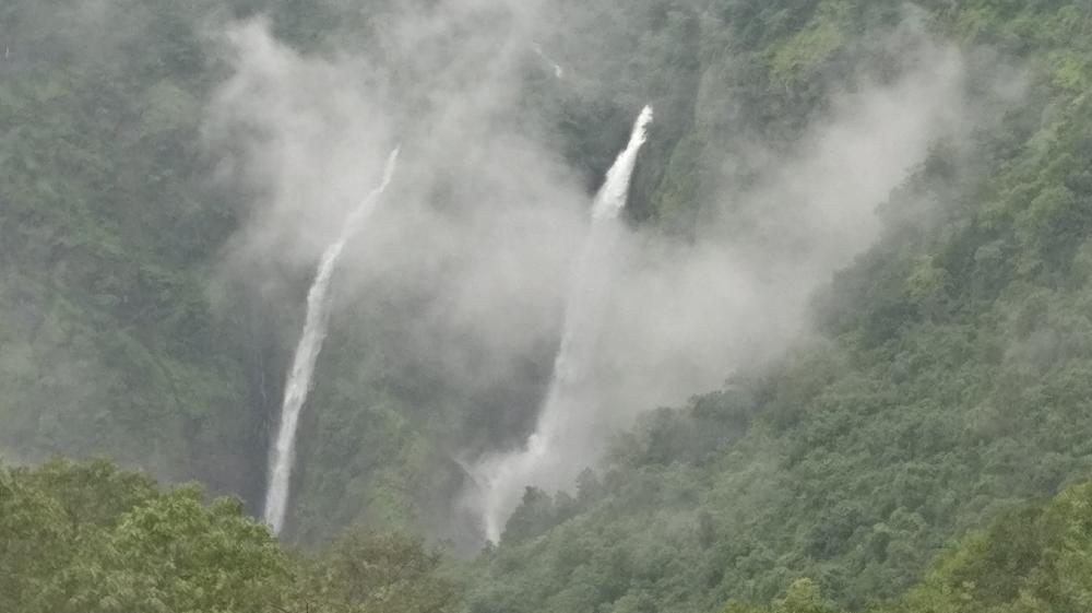 Majestic Waterfalls Surrounded by Misty Mountains wallpaper