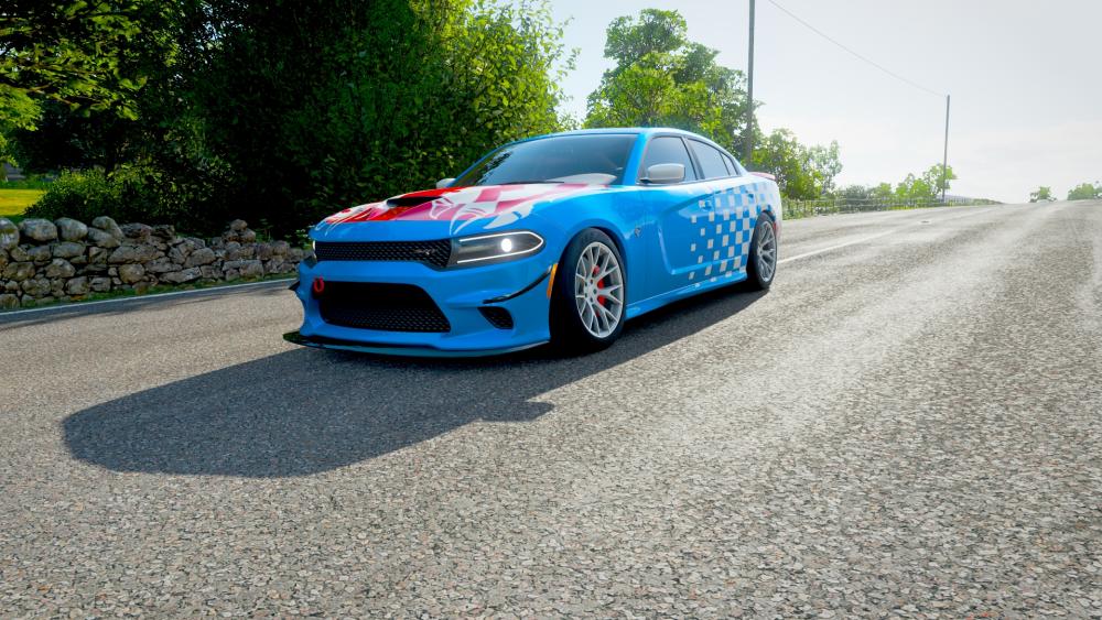 Vibrant Blue Race Car on Scenic Roadway wallpaper