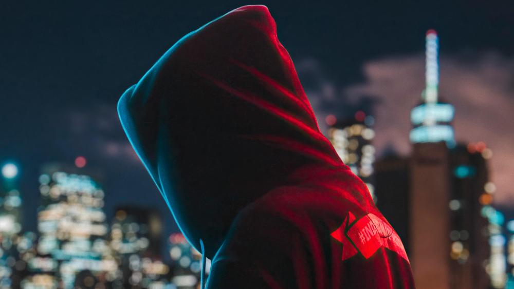 Mysterious Figure Against the City Lights wallpaper