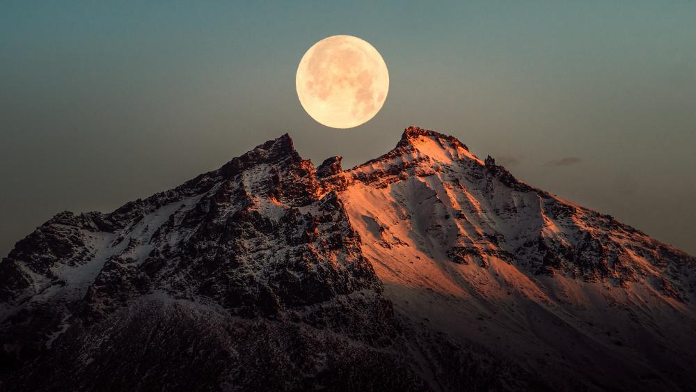 Stunning moonrise over a mountain peak wallpaper