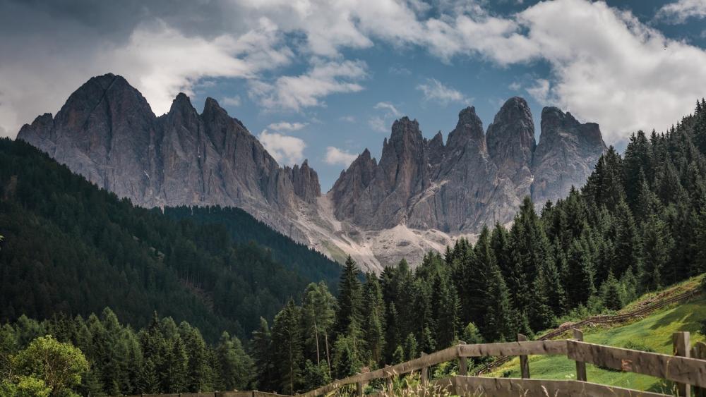 Majestic Mountain Peaks Surrounded by Lush Forests wallpaper