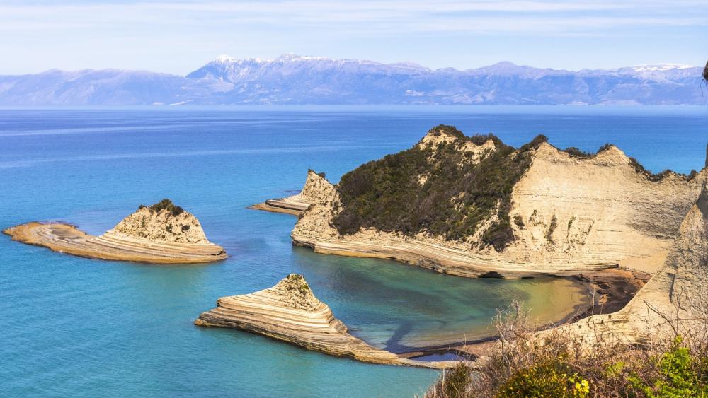 Serene Coastal Landscape with Striking Rock Formations and Calm Waters wallpaper